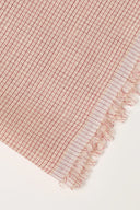 Tissu Le Carreau 010 rose poudré à fin quadrillage tissé ton sur ton, enroulé en rouleau laissant voir la lisière tissée.