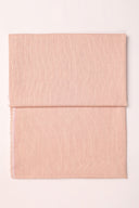 Tissu Le Carreau 010 rose poudré à fin quadrillage tissé ton sur ton, plié en deux et vu de dessus.