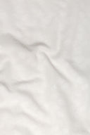 Tissu Le Coton Indien Tissé 001 écru drapé en plis souples, laissant deviner le motif floral tissé en relief à contre-jour.