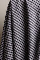 Close-up of the charcoal and ecru gingham check on the seersucker fabric, highlighting the irregular grain of the puckered texture.