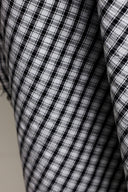 Extreme close-up of the charcoal and ecru gingham weave of the seersucker fabric.