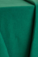 Tissu gabardine de coton vert émeraude, disposé en plis souples mettant en valeur son tombé.