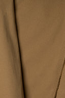 Tissu gabardine légère camel suspendu en plis fluides et asymétriques, lisière effilochée visible.