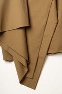 Gros plan sur le pli en pointe du tissu gabardine légère camel, texture sergé fine visible.