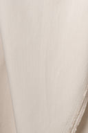 Gros plan sur les plis souples du tissu gabardine légère beige argile.