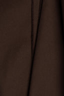 Chocolate brown light gabardine fabric hanging in flowing, asymmetric folds, selvedge visible on the side.