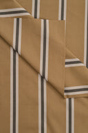 Tissu Weave Line camel à rayures écrues et gris-bleu, plié en angle mettant en valeur le motif tissé.