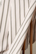 Weave Line fabric, off-white with fine grey-blue and mustard stripes, draped in diagonal folds.