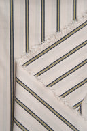 Weave Line fabric, off-white with fine grey-blue and mustard stripes, folded to a point with its frayed selvedge visible.