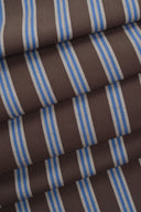 Close-up of the Weave Line chocolate brown fabric with sky-blue stripes, pleated into a fan shape.